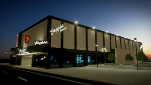 nighttime at a big building with show lights at the front and a plaza next to it