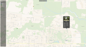 A digital map interface showing a suburban area with roads, parks, and rivers. Three colored markers are present, and a pop-up displays information about "Building J" with a small exterior photo. A sidebar menu is on the left.
